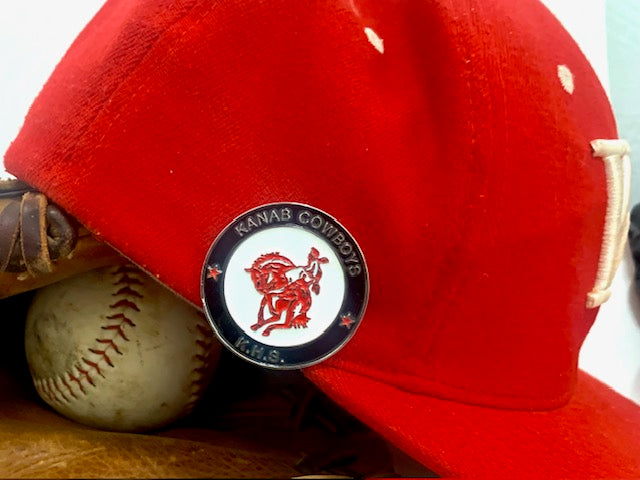 Red hat with Hat-tatt hat clip kanab highschool cowboys on top of baseball and baseball glove